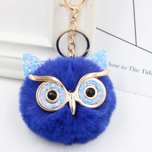 Detail of blue owl faux fur keychain with sparkling blue ears and golden metal eyes