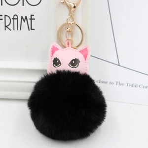 Détail de pendentif chat rose avec pompon noir et fermoir mousqueton en métal doré