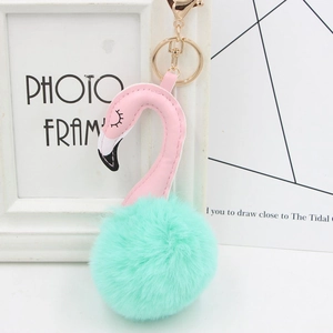 Detail of pink flamingo plush keychain with mint green faux fur ball and golden clasp