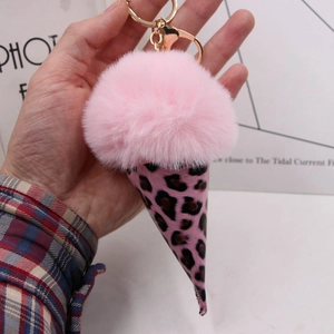Close-up of fluffy pink pom-pom ice cream keychain with leopard print cone detail