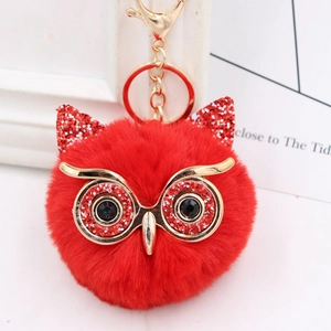 Detailed view of a red owl plush keychain with shiny sequins and golden metal clip