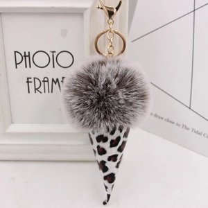 Detail of leopard print ice cream keychain with a fluffy faux fur ball and golden clasp