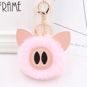 Close-up of pink fluffy pig plush keychain with golden metal hook and leather details