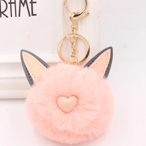 Gros plan du porte-clés en fourrure rose avec oreilles de chat et cœur rose