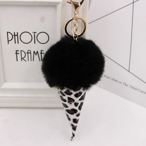 Close-up of fluffy black faux fur pompom ice cream keychain with leopard print cone