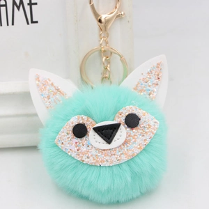 Close-up of mint green plush fox keychain with sparkling sequins and gold hardware