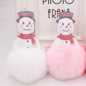 Close-up of cute plush snowman keychains with PU leather detail and fluffy pom poms