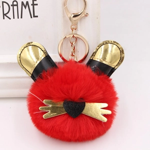 Détail du porte-clés lapin en peluche rouge avec oreilles dorées et fermoir métal