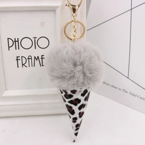 Close-up of fluffy gray fur pom pom and leopard print cone keychain with gold metal clasp