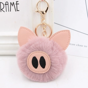 Close-up of pink pig plush keychain with soft faux fur ball and leather nose detail