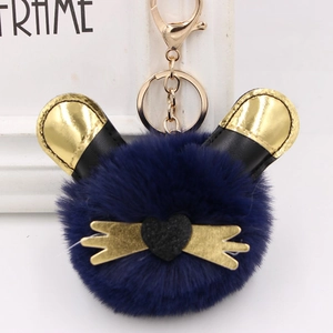 Gros plan sur un porte-clés en peluche bleue avec oreilles de chat dorées et cœur