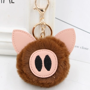 Detailed macro of plush pig keychain with brown faux fur and pink PU ears and snout