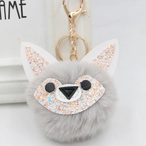 Detailed macro view of gray faux fur fox keychain with colorful sequins and golden clasp