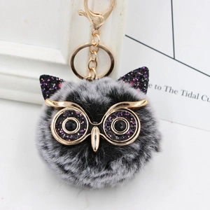 Detailed view of owl plush keychain featuring gold glasses and fluffy faux fur texture