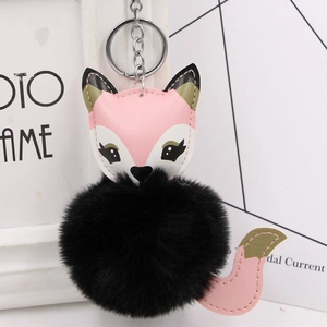 Detail of cute fox plush keychain with black faux fur pompom and silver metal ring