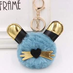 Détail d'un porte-clés chat en peluche bleue avec accents cœur doré et fermoir