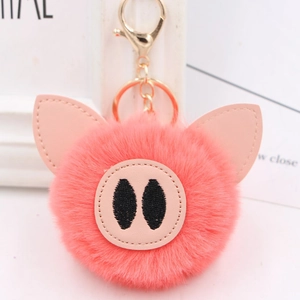 Detailed view of pink faux fur pig keychain with leather ears and golden metal lobster clasp