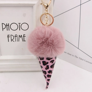 Close-up of a pink plush faux fur pom pom keychain with leopard print ice cream cone