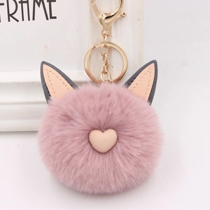 Détail d'un porte-clés en peluche rose avec oreilles de chat et bouton de cœur