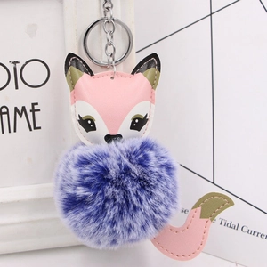 Close-up of pink leather fox keychain with a fluffy blue and white faux fur pompom