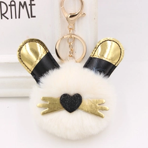 Gros plan du porte-clés lapin en peluche blanche avec oreilles noires et dorées