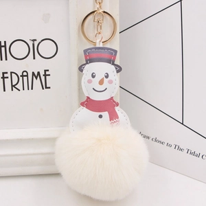 Close-up of snowman plush keychain with red scarf and white faux fur pompom on gold ring