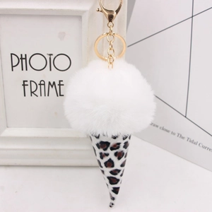 Close-up of leopard print ice cream keychain with fluffy white faux fur pompom and gold clasp