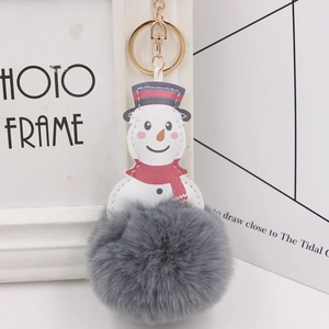 Close-up of a Christmas snowman faux fur pompom keychain with a red scarf and gold ring