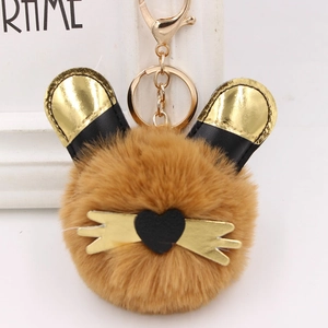 Gros plan du porte-clés en peluche marron avec oreilles de chat dorées et nez de cœur