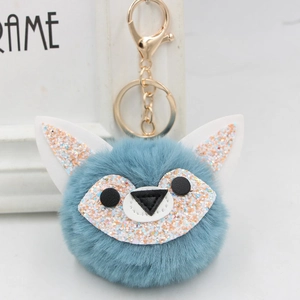 Detail of blue plush fox keychain featuring sparkling sequins and golden metal ring