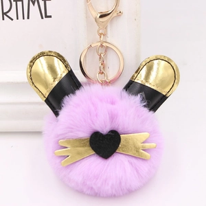 Gros plan du porte-clés en fourrure violette avec oreilles noires et boucle dorée