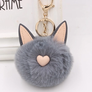Gros plan d'un porte-clés en peluche gris avec oreilles de chat et détails de cœur