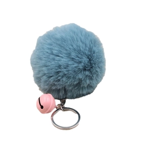 Fuffy faux fur keychain with blue pom pom, pink metal bell and silver ring on white back