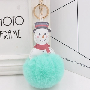 Detailed view of mint green pompom snowman keychain with gold clip and red scarf