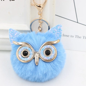 Detail view of light blue sequined owl faux fur keychain with golden clasp and metal ring