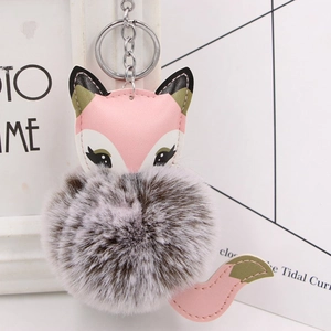 Close-up of cute pink fox faux fur pom-pom keychain with silver metal ring and chain