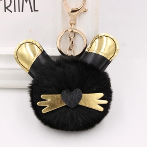 Gros plan du porte-clés chat en peluche noir avec oreilles dorées et fermoir