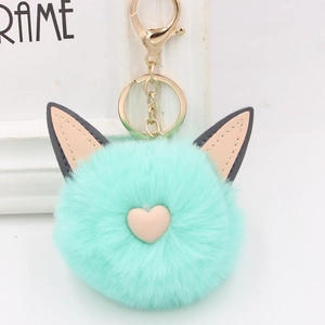 Gros plan du porte-clés en peluche vert menthe avec oreilles de chat et détail de cœur rose