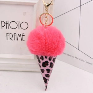 Close-up of pink leopard print ice cream keychain with plush pom pom and golden metal clasp