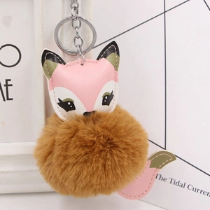 Close-up of fluffy brown faux fur fox keychain with pink faux leather and silver metal ring