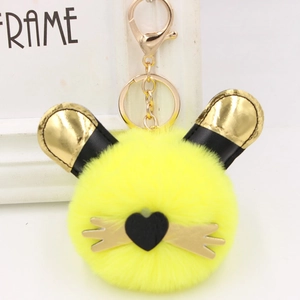 Détail d'un porte-clés en peluche jaune avec breloque cœur et oreilles de lapin