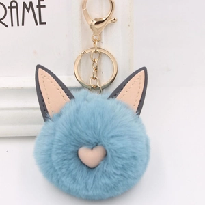 Vue détaillée du porte-clés en fausse fourrure bleu clair avec oreilles et cœur rose