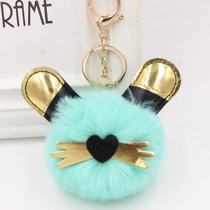 Gros plan du porte-clés lapin en peluche vert menthe avec des oreilles dorées