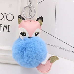 Close-up of fluffy blue faux fur fox keychain with silver metal clip and PU leather details
