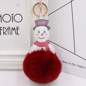 Detail of plush snowman keychain with red faux fur pompom and white leather charm