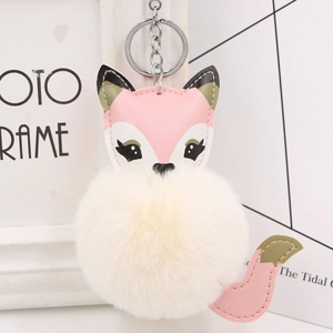 Detail of cute fox plush keychain with faux leather stitching and fluffy fur ball