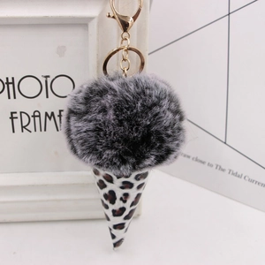 Detail view of ice cream keychain with grey plush ball, leopard print cone and gold ring