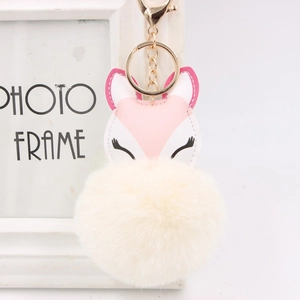 Detail of pink fox faux fur pompom keychain with gold ring and soft plush texture