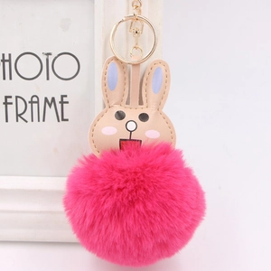 Close-up of cute pink fluffy rabbit keychain with gold lobster clasp and embroidery