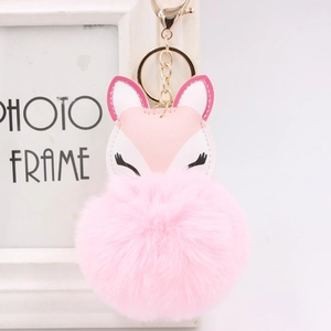 Detail of pink faux fur pom-pom keychain with leather fox head and golden metal clasp